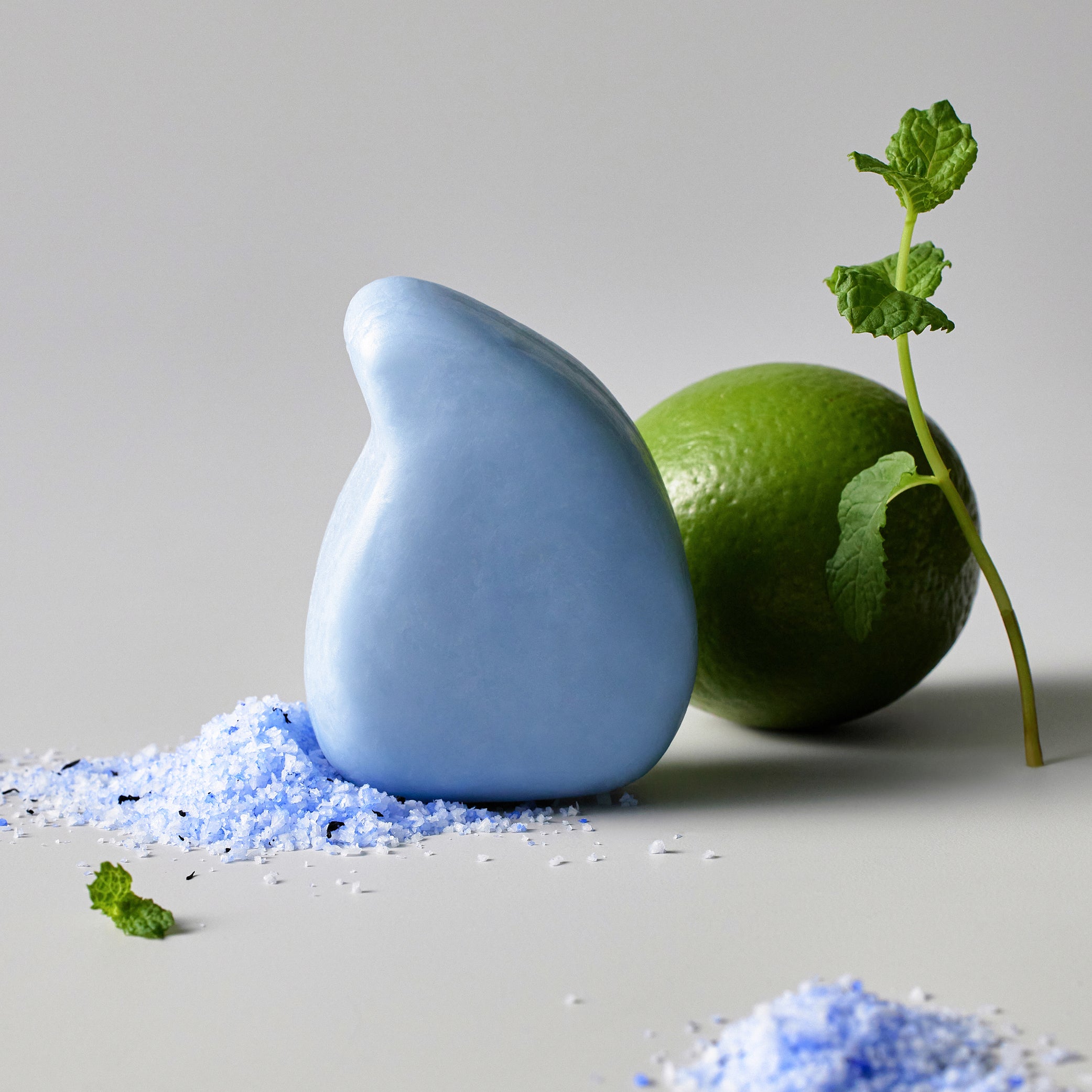 ReSaltZ Salt Massage Cleansing Bar Ocean and lime. Some blue bath salt are scattered on the floor.