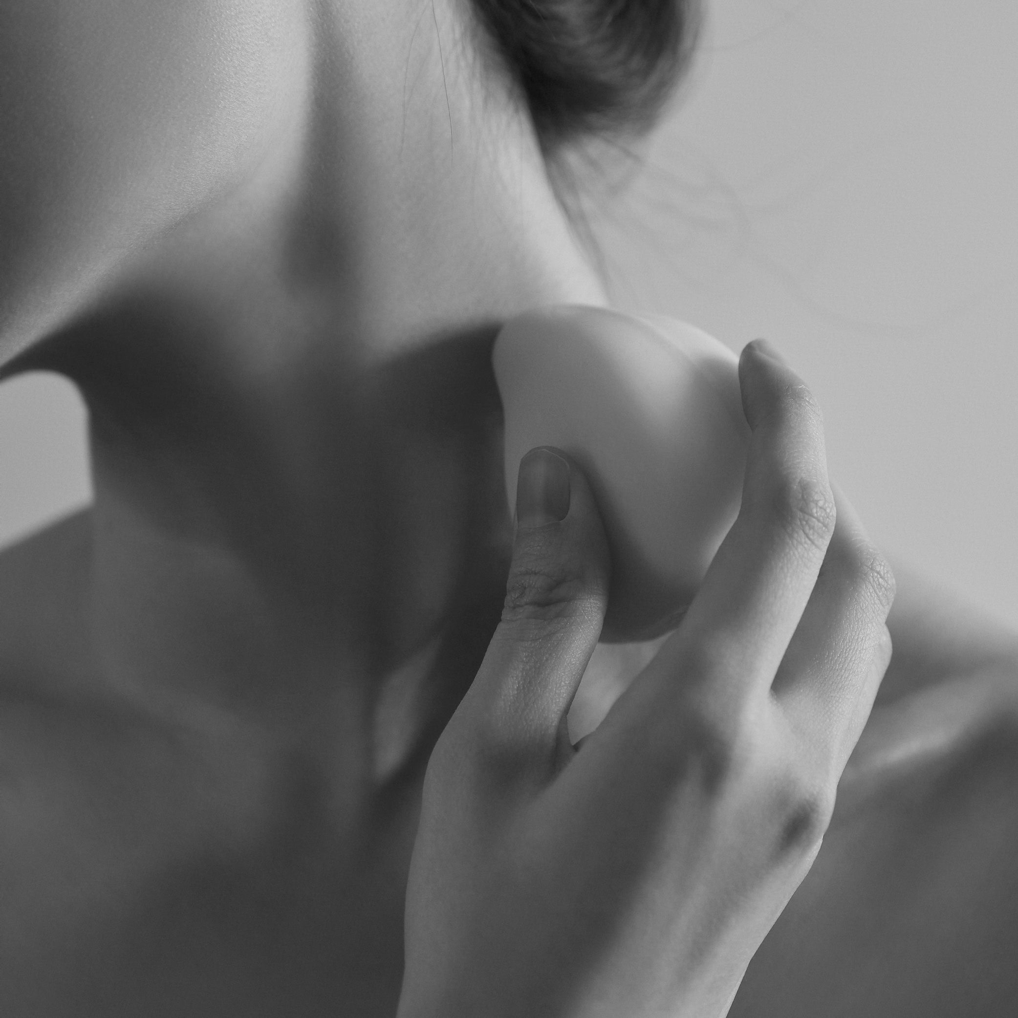ReSaltZ Salt Massage Cleansing Bar being held in hand, used to massage the neckline.